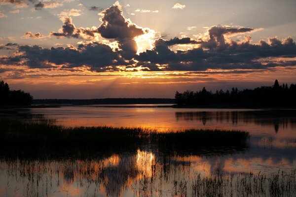 Өзендегі күннің батуының әдемі көрінісі