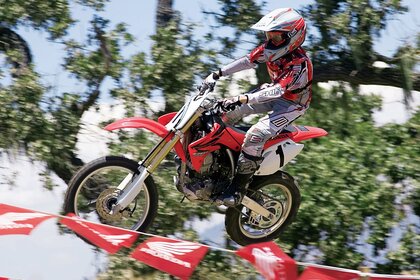 Шабандоз велосипедпен жалаулардан жоғары көтеріледі